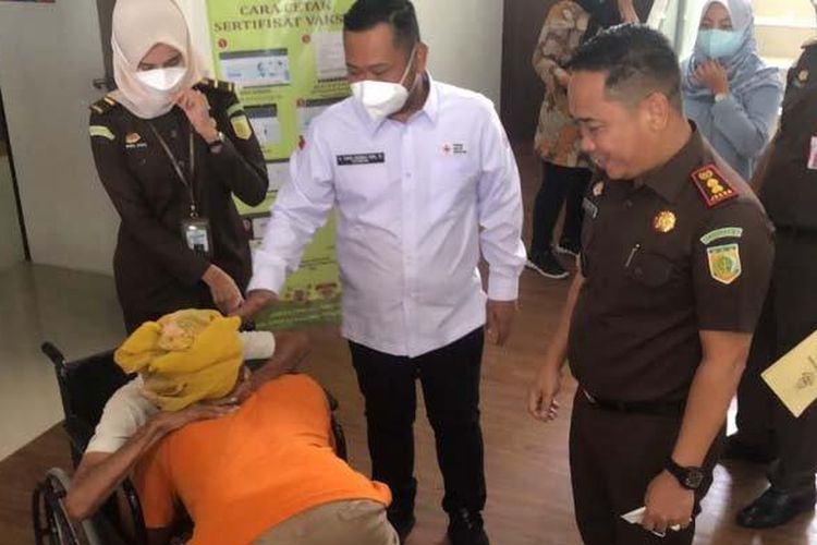 Kajari Gresik, Muhamad Hamdan (kanan) dan Bupati Gresik, Fandi Akhmad Yani (baju putih), menghibur Umar Buang alias Sholikan yang memeluk neneknya, Jumat (4/1/2022). 
