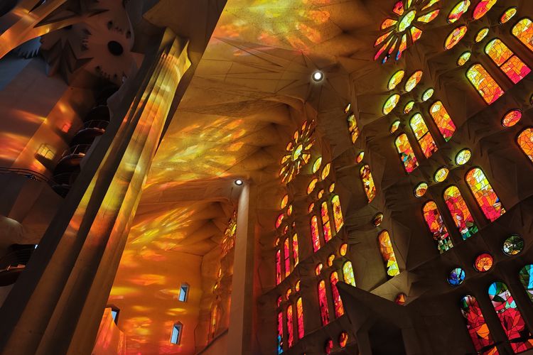 Pemandangan interior Gereja Sagrada Familia di Barcelona, Spanyol yang memperlihatkan efek pendaran cahaya matahari sore dari jendela, sebagaimana diabadikan oleh kamera utama Xiaomi 14.