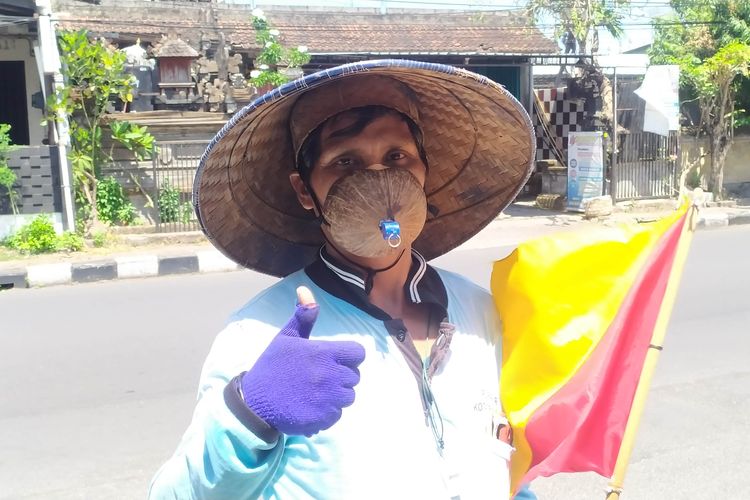 Nengah Budiasa (44) Juru parkir di Kota Denpasar yang memakai masker yang terbuat dari batok kelapa.