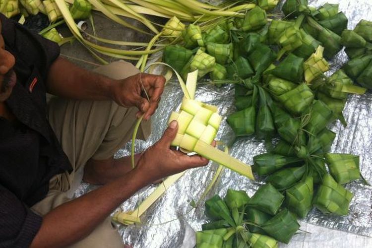 Pedagang kulit ketupat tengah membuat kulit ketupat yang terbuat dari daun kelapa di Tanah Abang, Jakarta Pusat, Selasa (6/8/2013)