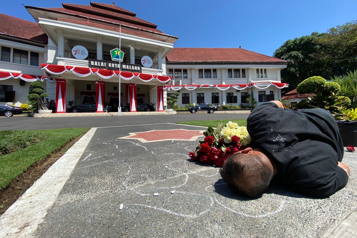 Seniman bernama Mukmin Ahmad (44) dari Malang Performance Art Community melakukan aksi teatrikal dengan menggambar jejak tubuhnya sendiri di halaman Balaikota Malang pada Kamis (10/8/2023), siang.