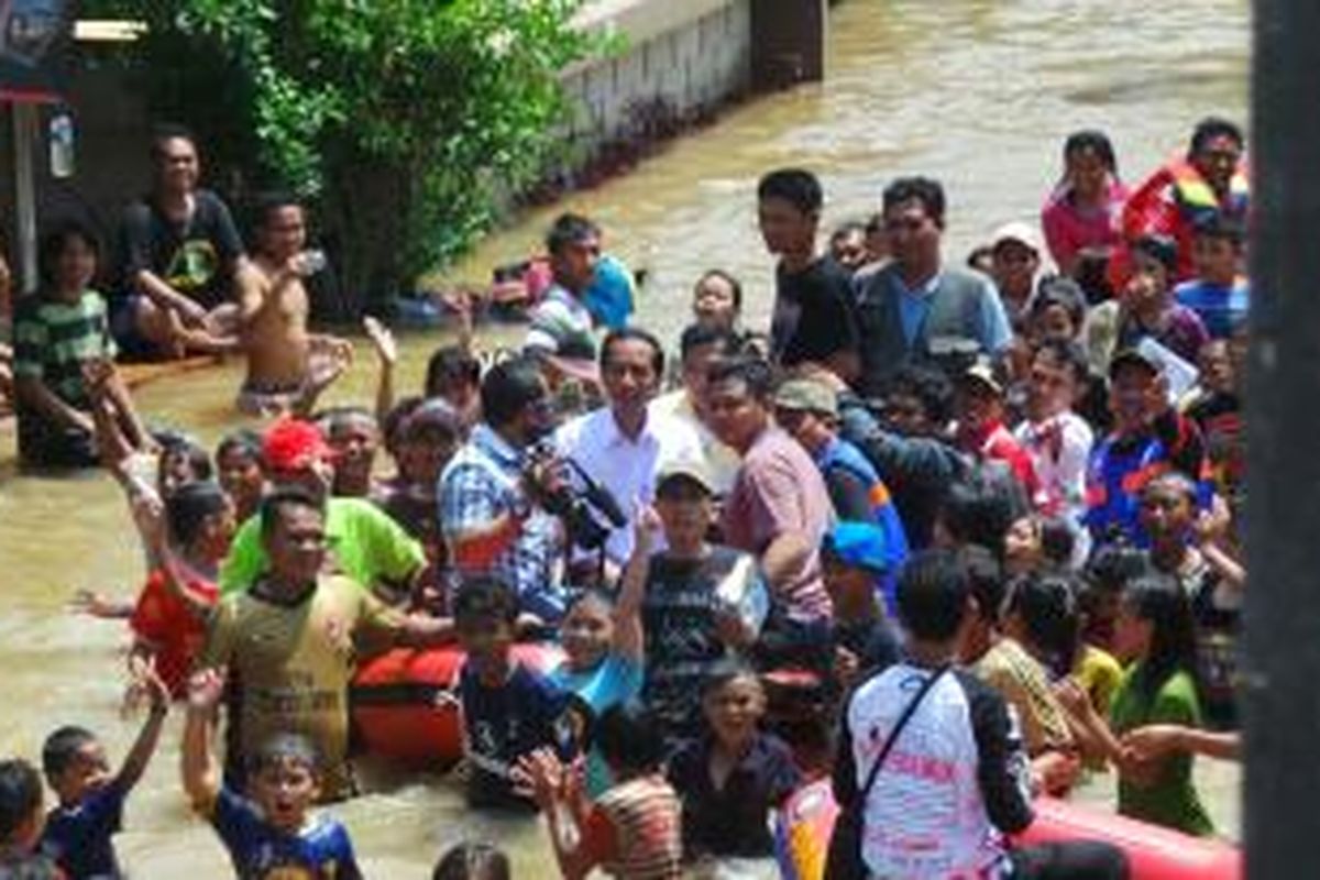 Gubernur Jakarta Joko Widodo yang menaiki perahu karet diarak warga korban banjir Kembangan Utara, Cengkareng, Jakarta Barat, Selasa (14/1/2014).