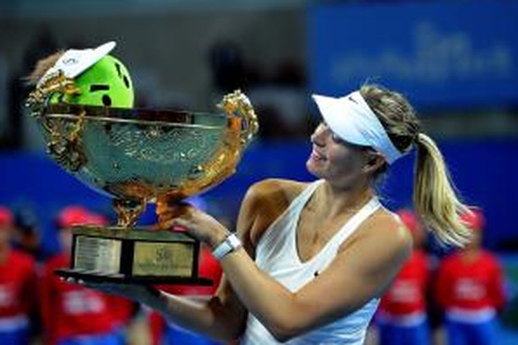 Petenis Rusia, Maria Sharapova, berpose dengan mengangkat trofi juara China Terbuka yang didapat setelah memenangi laga final melawan Petra Kvitova (Ceko) di National Tennis Center, Beijing, Minggu (5/10/2014).