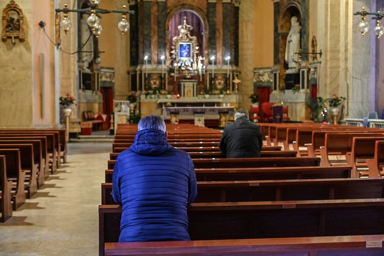 Sejumlah orang berdoa di gereja Santa Maria delle Grazie alle Fornaci, di Distrik Aurelio di sentral Roma, pada 15 Maret 2020. Peristiwa ini terjadi di tengah lockdown yang diterapkan Italia guna memerangi virus corona.