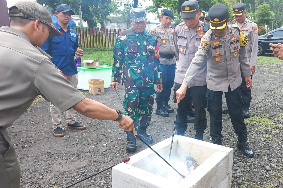 Anggota Polri, TNI, dan KPU Kabupaten Malang saat memusnahkan surat suara rusak dalam Pilkada 2024, Selasa (26/11/2024).