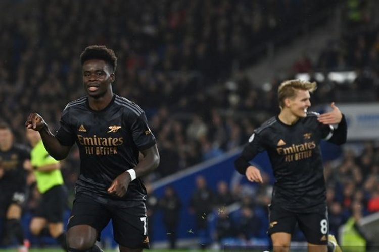 Winger Arsenal Bukayo Saka (kiri) merayakan golnya ke gawang Brighton and Hove Albion pada laga pekan ke-18 Liga Inggris 2022-2023 di Stadion American Express, Minggu (1/1/2023) dini hari WIB.