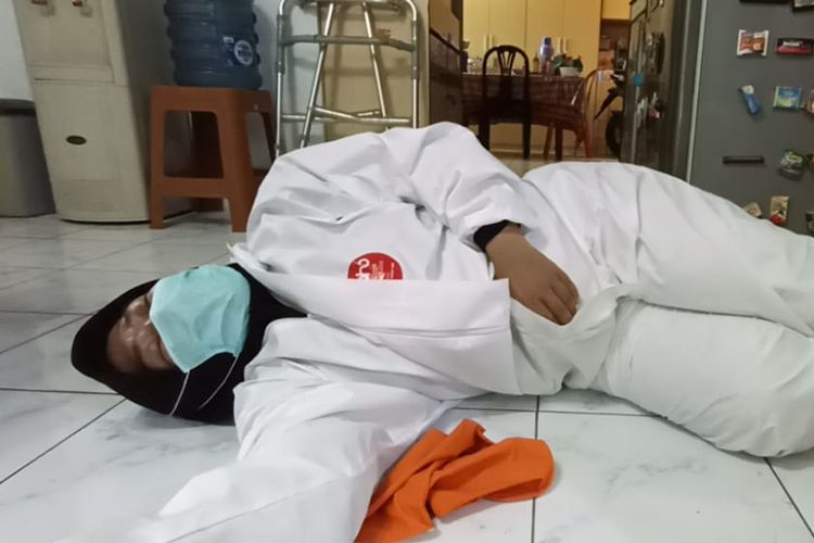 Seorang relawan pemulasaraan jenazah pasien Covid-19 di Pancoran Mas, Depok, Jawa Barat, terkulai kelelahan di rumah duka karena harus mengurusi banyaknya kematian dalam sehari.