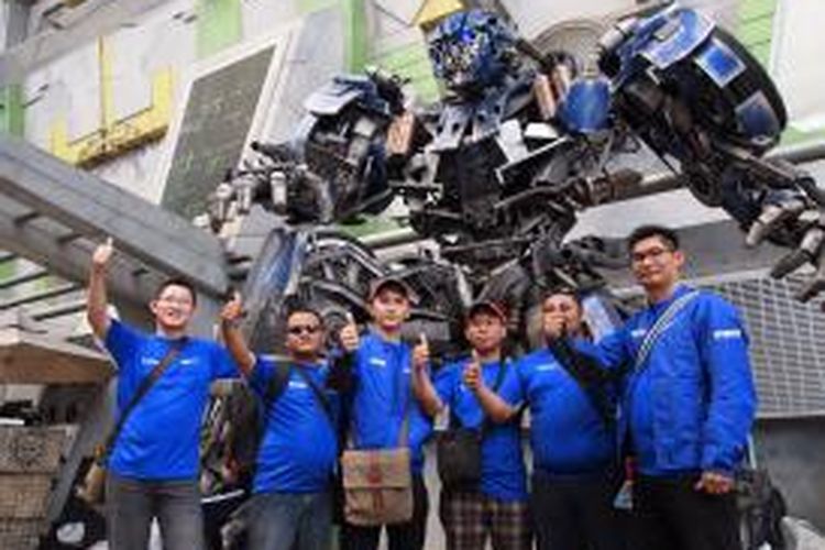 Beberapa peserta rombongan Yamaha yang akan menyaksikan langsung GP Malaysia, berpose di depan patung transformer, Jumat (11/10/2013).