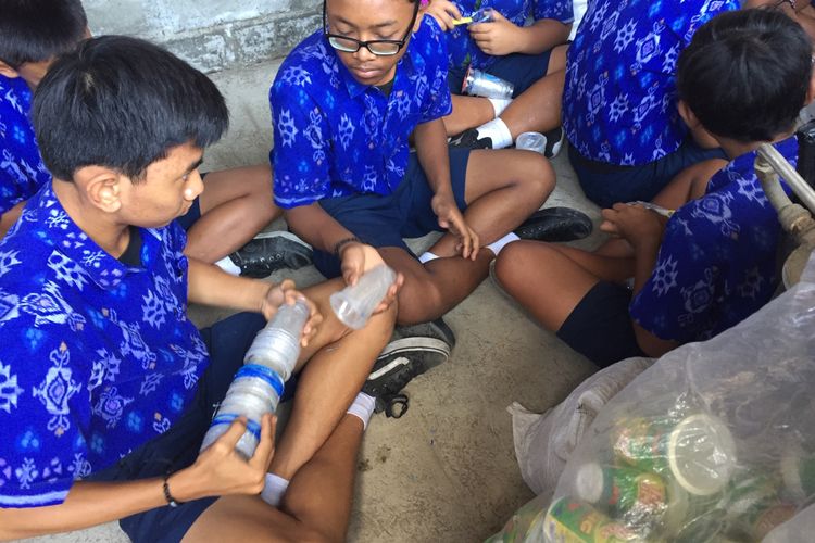 Para murid SMP Wisata Sanur Bali memisahkan botol plastik PET dari label, ring, dan tutupnya.