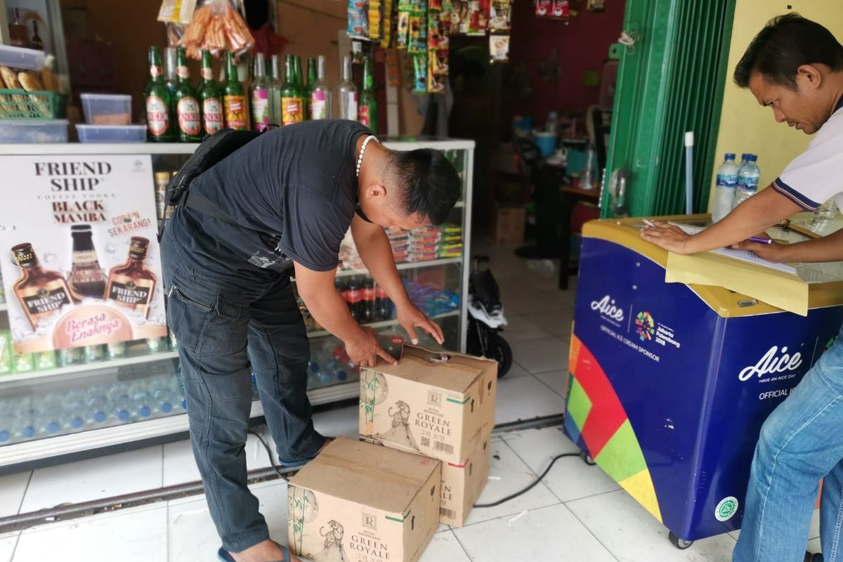 Petugas polisi saat mendatangi warung penjual miras tanpa izin di Jalan Cipendawa, Jatiasih, Kota Bekasi, Rabu (24/8/2022). Dari warung miras tak berizin tersebut, polisi turut menyita 36 botol miras bermerek Intisari.
