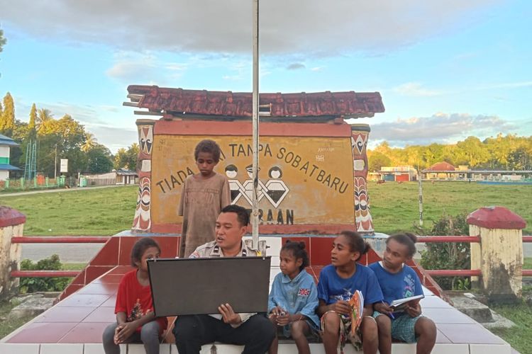 Bhabinkamtibmas Polsek Nimboran, Aipda Harnan Duwiri, terlihat menggunakan papan sederhana, mengajarkan baca dan tulis kepada beberapa anak di Kelurahan Tabri, Distrik Nimboran, Kabupaten Jayapura, Papua, Senin (29/5/2023).