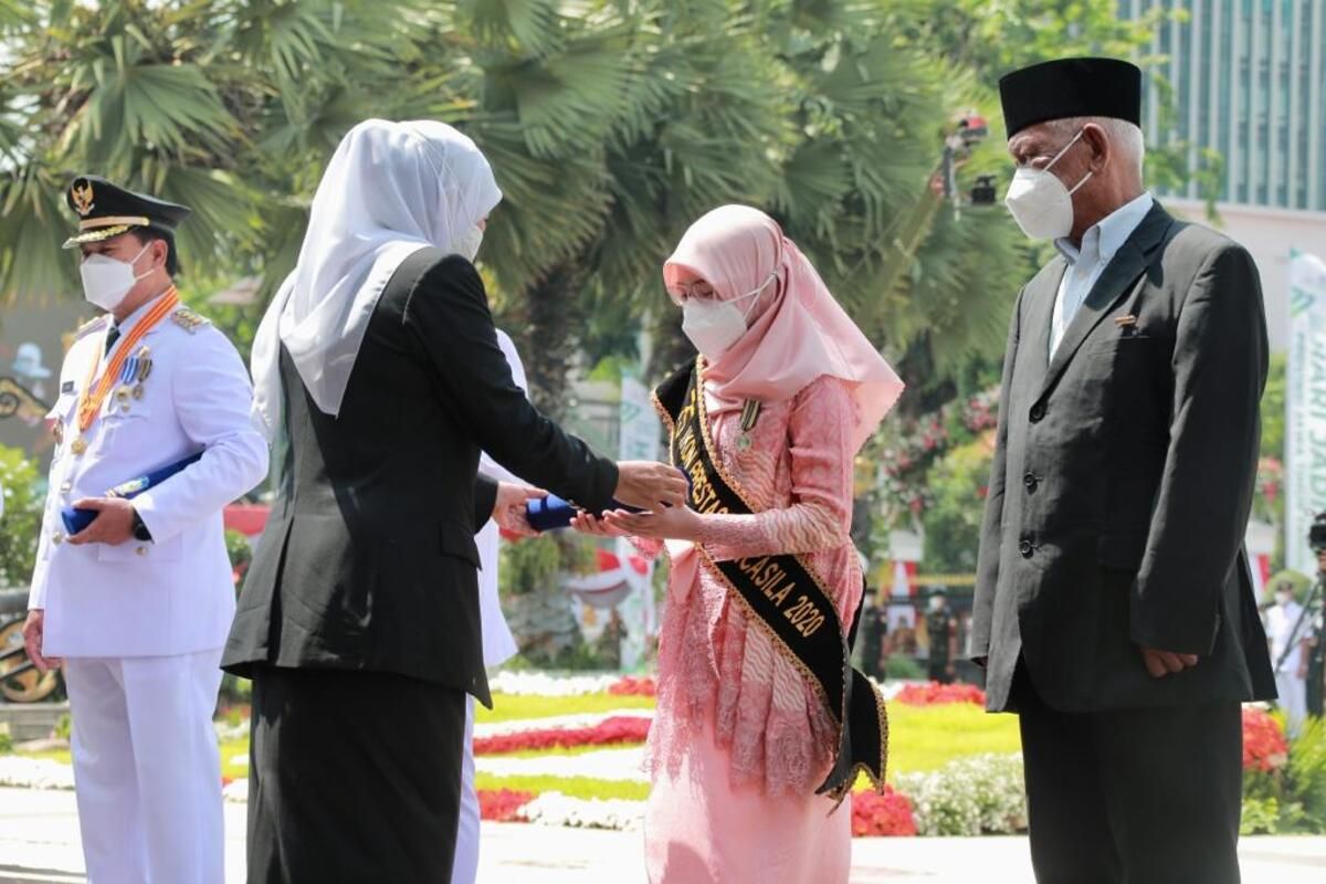 Khofifah memberikan penghargaan Jer Basuki Mawa Beya kepada Cleona Einar Maulidiva saat upacara peringatan HUT Provinsi Jatim di Gedung Negara Grahadi Surabaya, Rabu (12/10/2022).