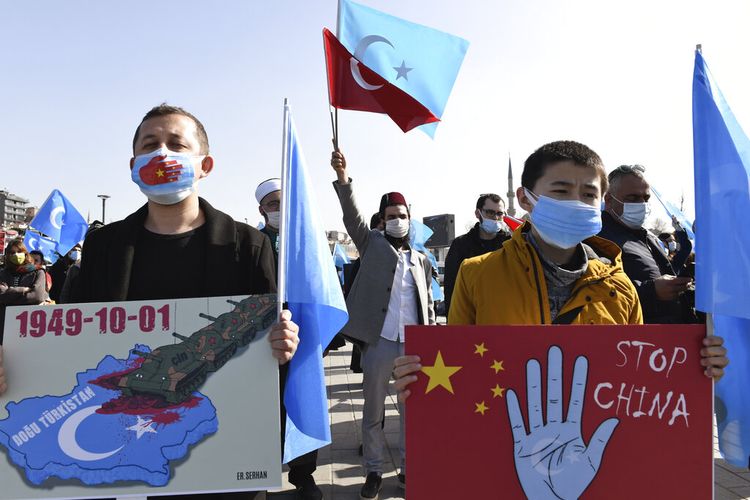 Anggota komunitas Uighur yang tinggal di Turki, memegang spanduk saat bergabung dalam protes melawan China, di Istanbul, Jumat (26/2/2021).