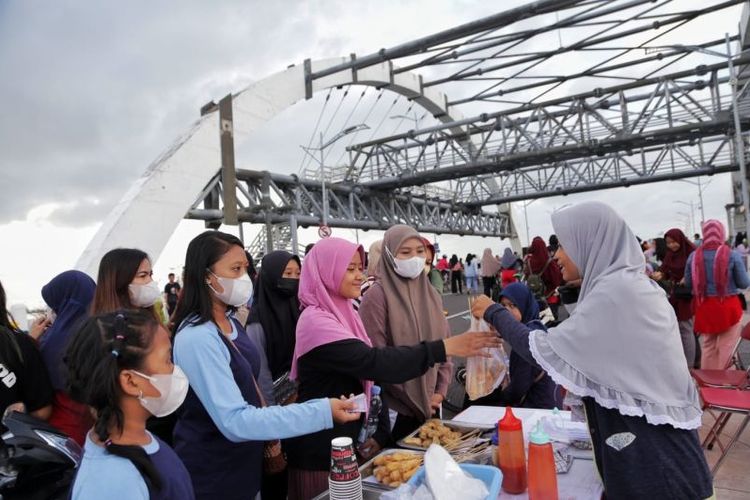 Sejumlah warga membeli produk UMKM dan food truck saat pelaksanaan CFD di Jembatan Surabaya, Minggu (3/7/2022).