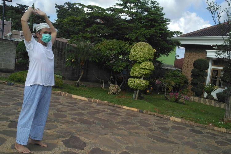 Marzuki (54) pasien corona yang sudah dinyatakan sembuh sedang berolahraga ringan di halaman rumahnya, Selasa (21/4/2020). Marzuki berusaha tenang dengan membaca Al Quran selama masa isolasi di rumah sakit.