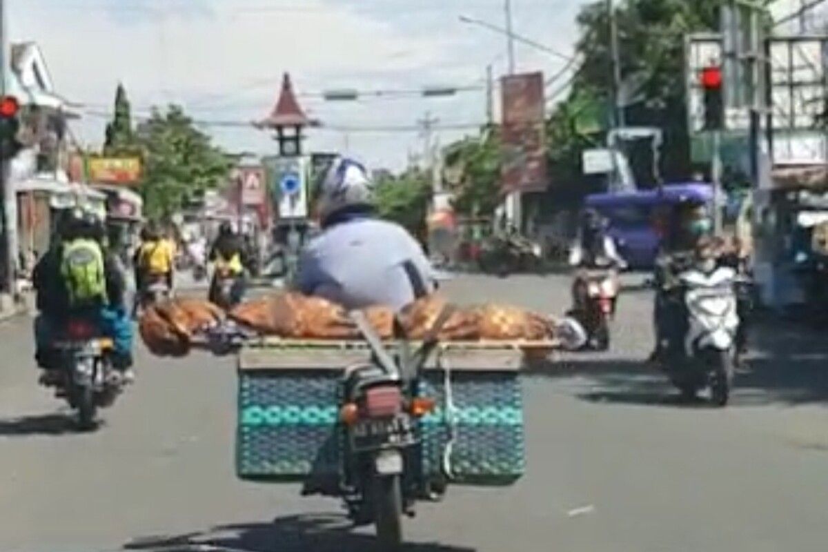 Tangkapan layar video viral seorang pemotor membawa jenazah di atas beronjong.