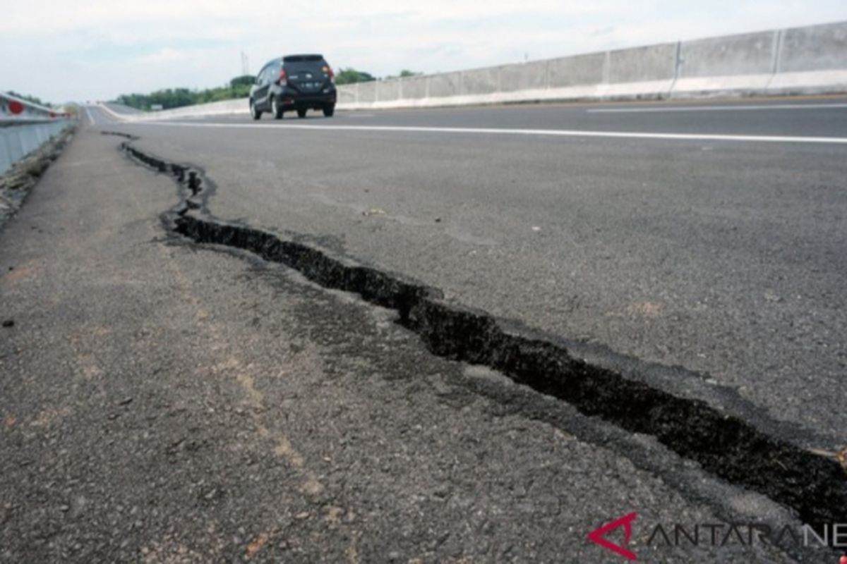 Sebuah kendaraan melintas di ruas jalan tol Pemalang-Batang yang retak di KM 321, Kelangdepok, Kecamatan Bodeh, Kabupaten Pemalang, Jawa Tengah, Jumat (18/1/2019). Jalan retak sepanjang 50 meter tersebut akibat longsor pada sisi selatan jalan tol dampak curah hujan yang tinggi sejak Rabu (16/1/2019) sore.