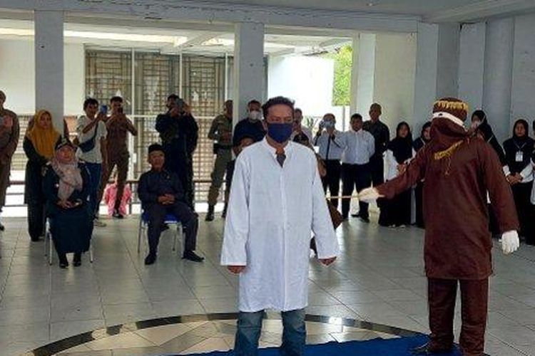 Seorang oknum PNS menjalani hukuman cambuk karena jadi bandar chip domino, Selasa (2/8/2022), di Taman Sari, Banda Aceh. 
