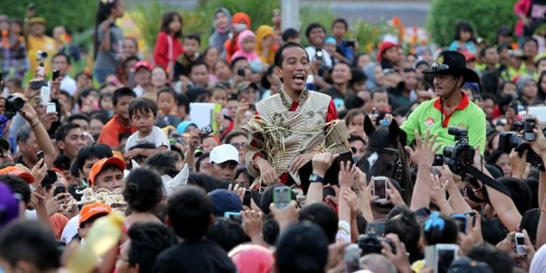 Gubernur DKI Jakarta, Joko Widodo mengikuti arak-arakan Jakarnaval 2013 di kawasan Bundaran Hotel Indonesia, Jakarta, Minggu (30/6/2013). Jakarnaval 2013 yang diikuti sekitar 4500 peserta tersebut sebagai rangkaian peringatan HUT Ke-486 DKI Jakarta.  