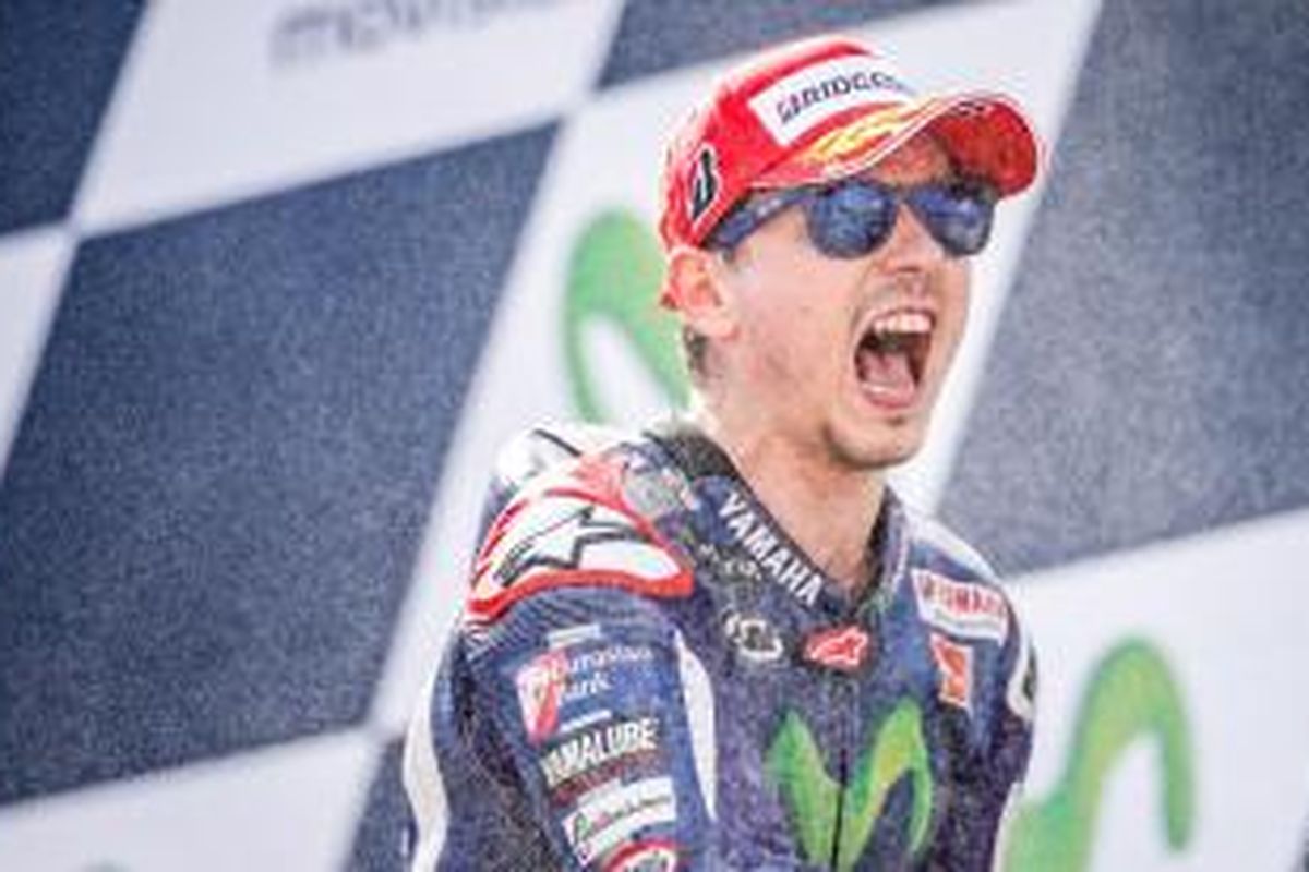 Pebalap Movistar Yamaha asal Spanyol, Jorge Lorenzo, merayakan kemenangan pada GP Paragon di atas podium Sirkuit MotorLand, Minggu (27/9/2015).