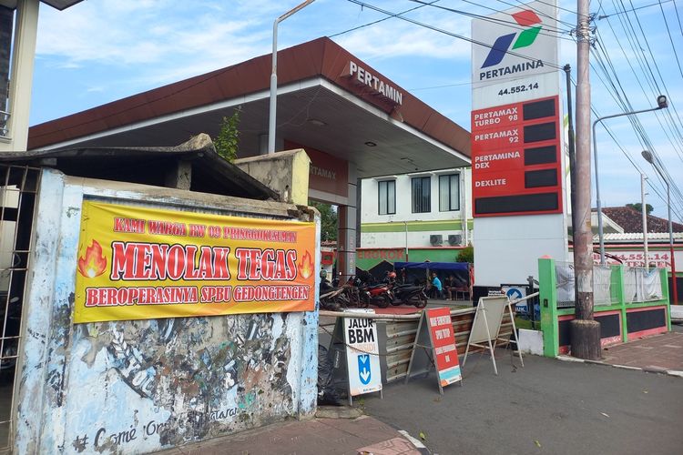 Spanduk yang dipasang warga d tembok samping SPBU Gedongtengan yang alami ledakan beberapa waktu lalu, Senin (30/6/2025)