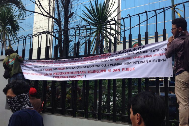 Sejumlah warga RW 01 Kelurahan Ulujami, Jakarta Selatan, memasang spanduk berisi tuntutan di depan kantor Kementerian ATR/BPN, Jakarta, Senin (17/7/2017).  Mereka menuntut agar 131 sertifikat tanah yang menjadi hak mereka segera diserahkan.