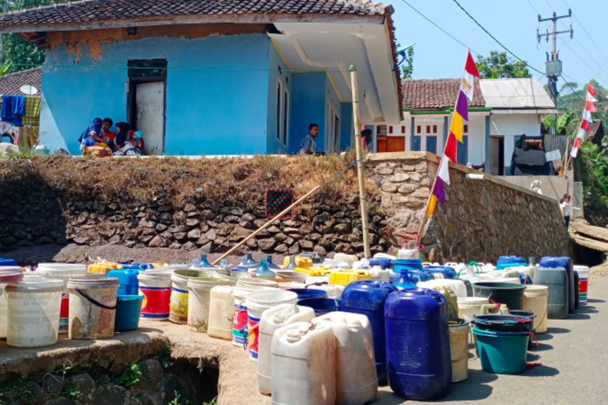 Puluhan wadah penampung air di simpan di pinggir jalan menunggu kedatangan truk tangki pengangkut air bersih di Kampung Siderang Satar Desa Cintanagara, Kamis (10/08/2023)