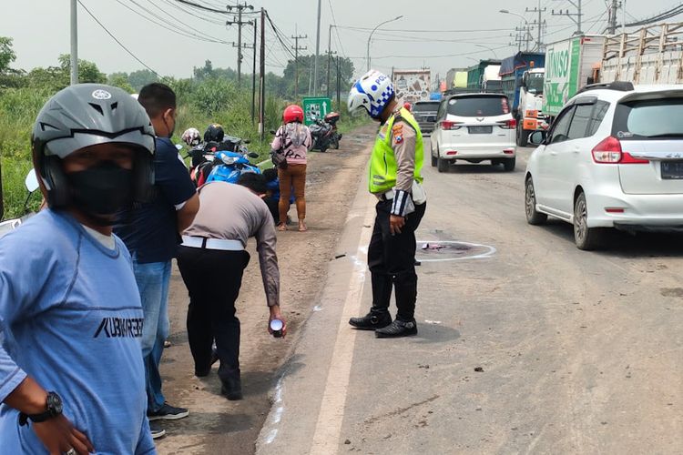 Pihak kepolisian saat menandai lokasi terjadinya kecelakaan yang menewaskan Sukarti di Jalan Raya Manyarrejo, Kecamatan Manyar, Gresik, Rabu (30/3/2022).