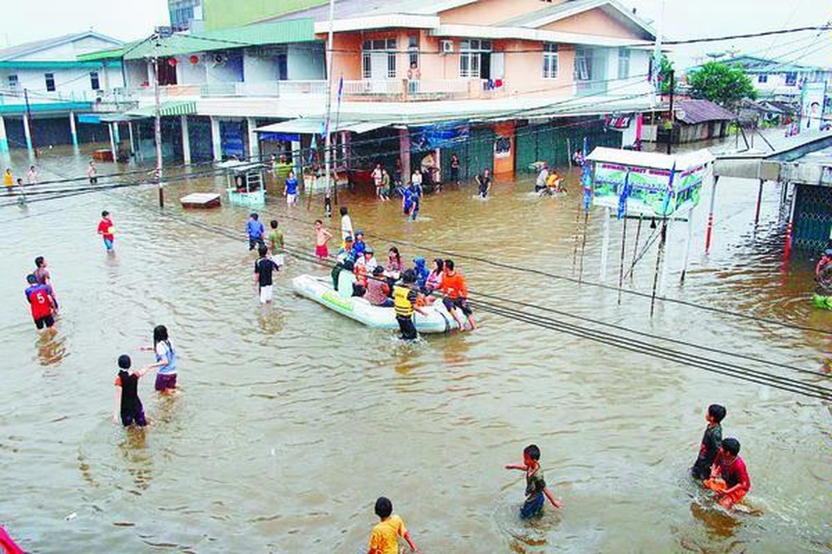 Patients and visitors of Harapan Bersama Hospital in Singkawang City, West Kalimantan, are evacuated with rubber boats on Dec. 17, 2010 when the area is inundated with flood.