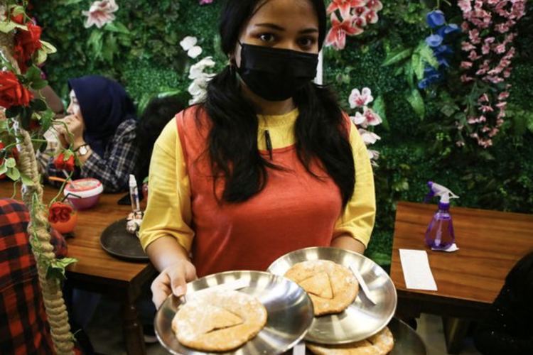 Pramusaji memperlihatkan kue dalgona yang populer di dalam film Squid Game yang diadopsi di Strawberry Cafe di kawasan Duri Kepa, Jakarta Barat, Sabtu (16/10/2021).