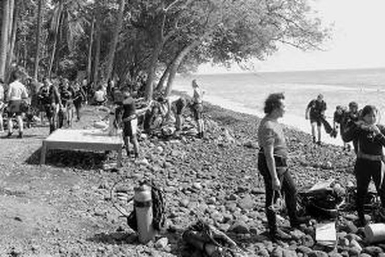 Para penyelam berkumpul di pinggir pantai di perairan Tulamben, Karangasem, Bali, Jumat (29/8/2014), untuk mempersiapkan penyelaman. Suasana amat ramai sehingga lokasi itu biasa disebut ”pasar pagi” penyelam Tulamben. Jumlah kunjungan wisatawan di daerah ini dinilai terlalu padat sehingga butuh pengaturan atau pembatasan jumlah turis di obyek wisata minat khusus itu.