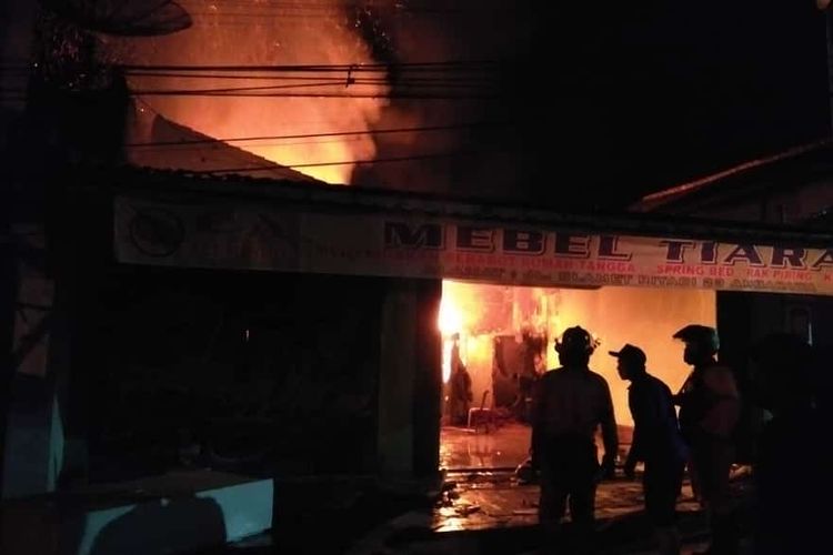 Petugas berupaya memadamkan api yang membakar toko mebel Tiara