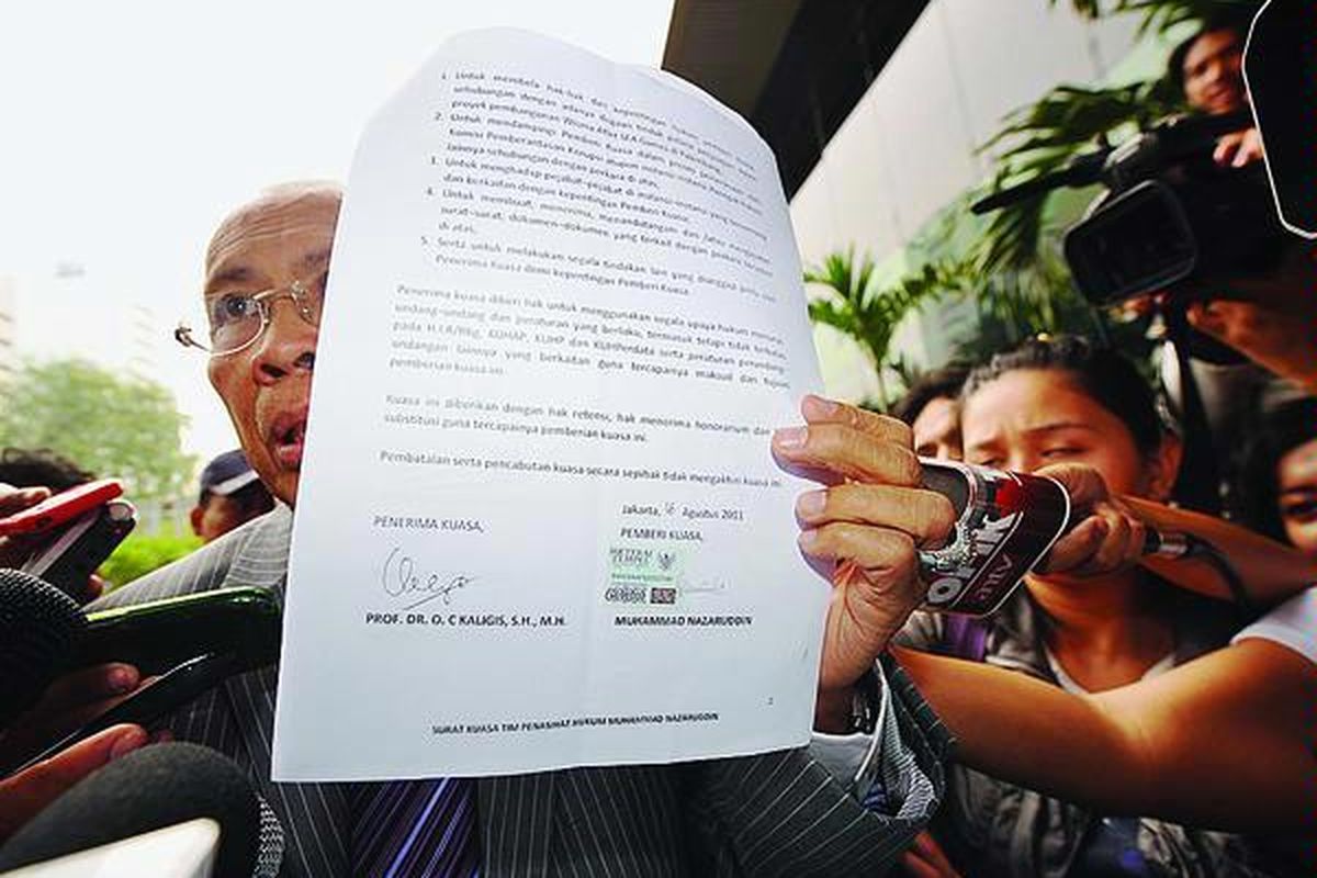 Pengacara OC Kaligis (tengah) mendatangi kantor Komisi Pemberantasan Korupsi, Jakarta, sambil membawa surat kuasa bertanda tangan Muhammad Nazaruddin, Kamis (18/8). Kaligis mengaku akan mendampingi mantan Bendahara Umum Partai Demokrat itu selama menjalani pemeriksaan di KPK  sebagai tersangka suap proyek wisma atlet SEA Games di Palembang.