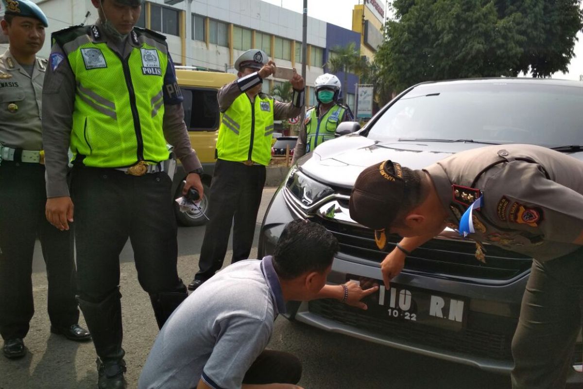 Kapolres Karawang AKBP Ade Ary Syam Indradi (kanan) dan Anggota DPRD Karawang Hitler Nababan saat menunjukkan plat nomor yang yang tidak sesuai.