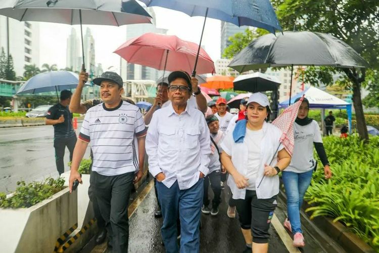 Menko Polhukam Mahfud Md bersama Komnas HAM berjalan kaki di tengah guyuran hujan dalam rangka mendorong percepatan pengesahan RUU PPRT di kawasan Sudirman, Jakarta Pusat (Jakpus), Minggu (12/2/2023). 