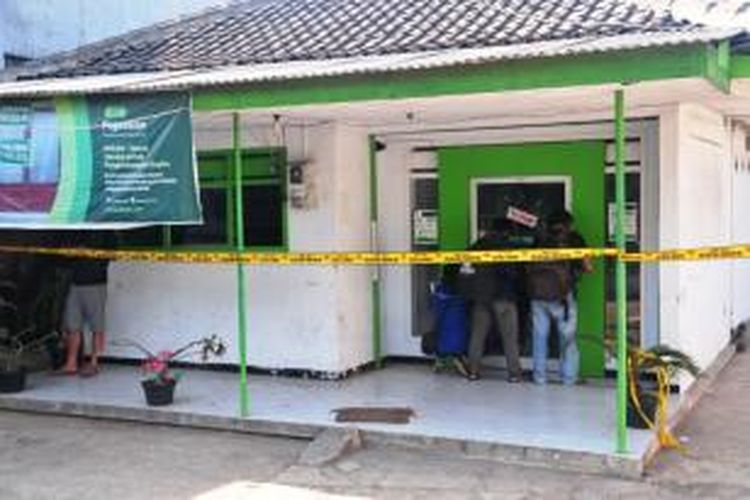 Polisi memasang garis polisi di Kantor Pegadaian Kecamatan Bangsalsari, Jember, Jawa Timur, Senin (21/9/2015)
