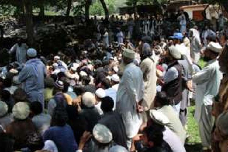 Penduduk di Desa Ursoon, Chitral, Pakistan berkumpul setelah banjir bandang.