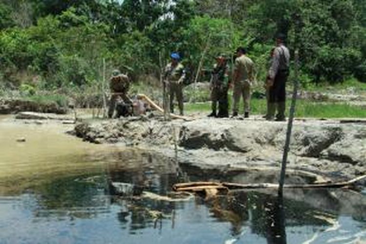 Beberapa aparat gabungan saat memusnahkan barang bukti yang digunakan penambang di lokasi tambang emas tanpa izin (PETI)dalam operasi penertiban di Kelurahan Sanggau Kulur, Singkawang, Kalimantan Barat (1/10/2013) 