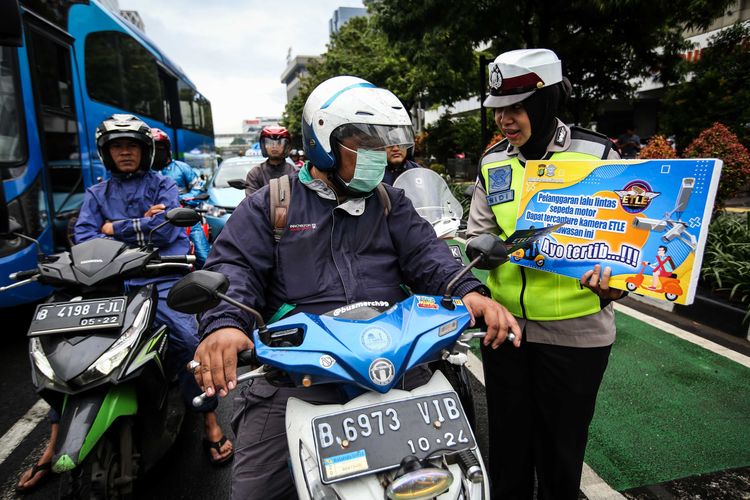 Ilustrasi pengendara sepeda motor yang menggunakan masker