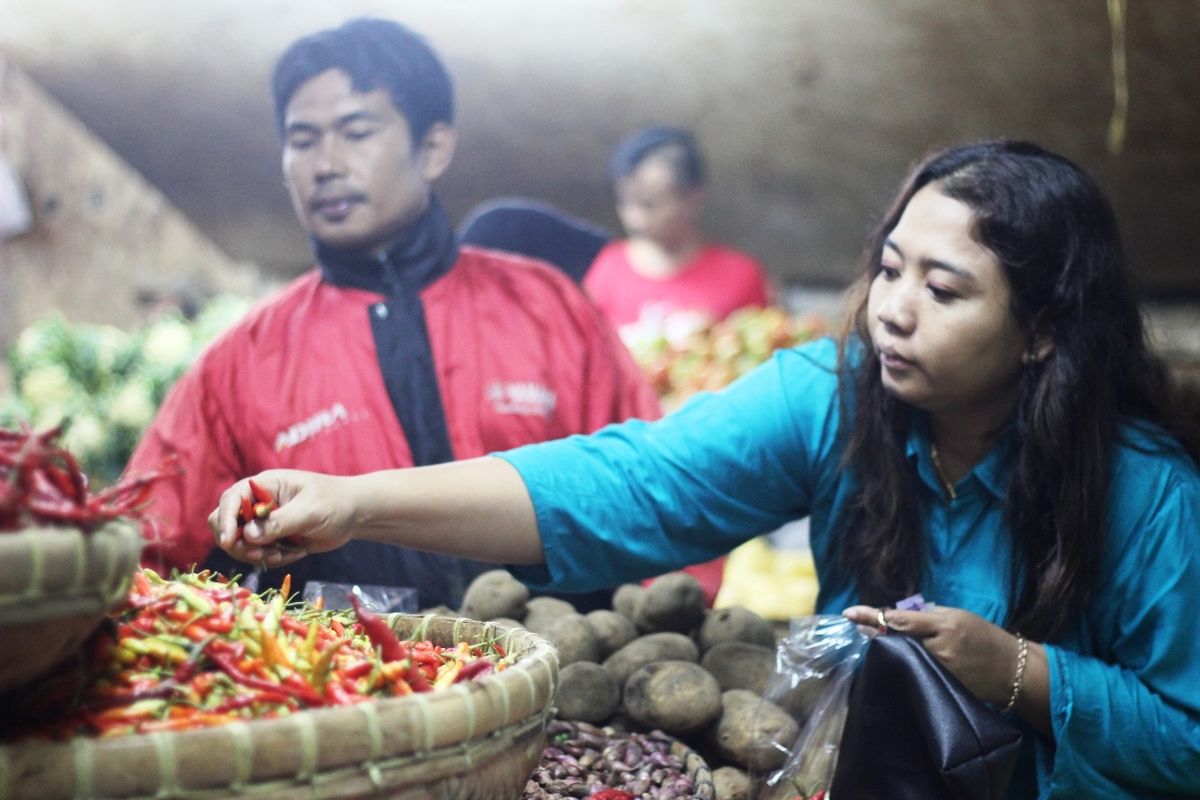 Seorang pembeli sedang memilih cabai di lapak pedagang sayuran di Pasar Muka Cianjur, Jawa Barat