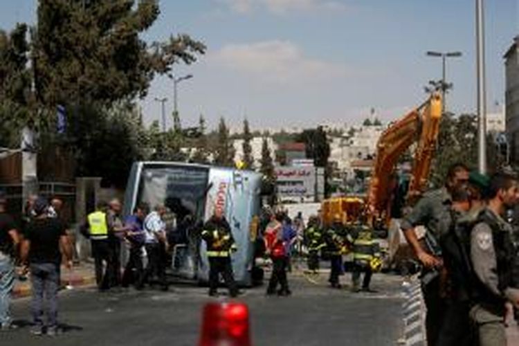 Tim penolong dan polisi berada di lokasi sebuah ekskavator yang menabrak sebuah bus di Jerusalem, Senin (4/8/2014), mengakibatkan satu orang tewas dan lima lainnya terluka.