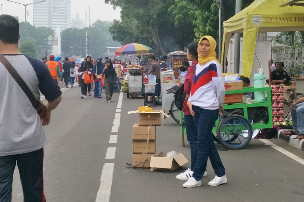 Para pedagang kaki lima (PKL) membuka lapaknya di badan jalan Sudirman-Thamrin saat car free day (CFD) digelar, Minggu (9/12/2018).