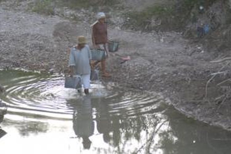 Warga Desa Bujur Barat, Kecamatan Batumarmar, Pamekasan, mengambil sisa-sisa air di sungai untuk kebutuhan mereka seperti mandi dan mencuci.