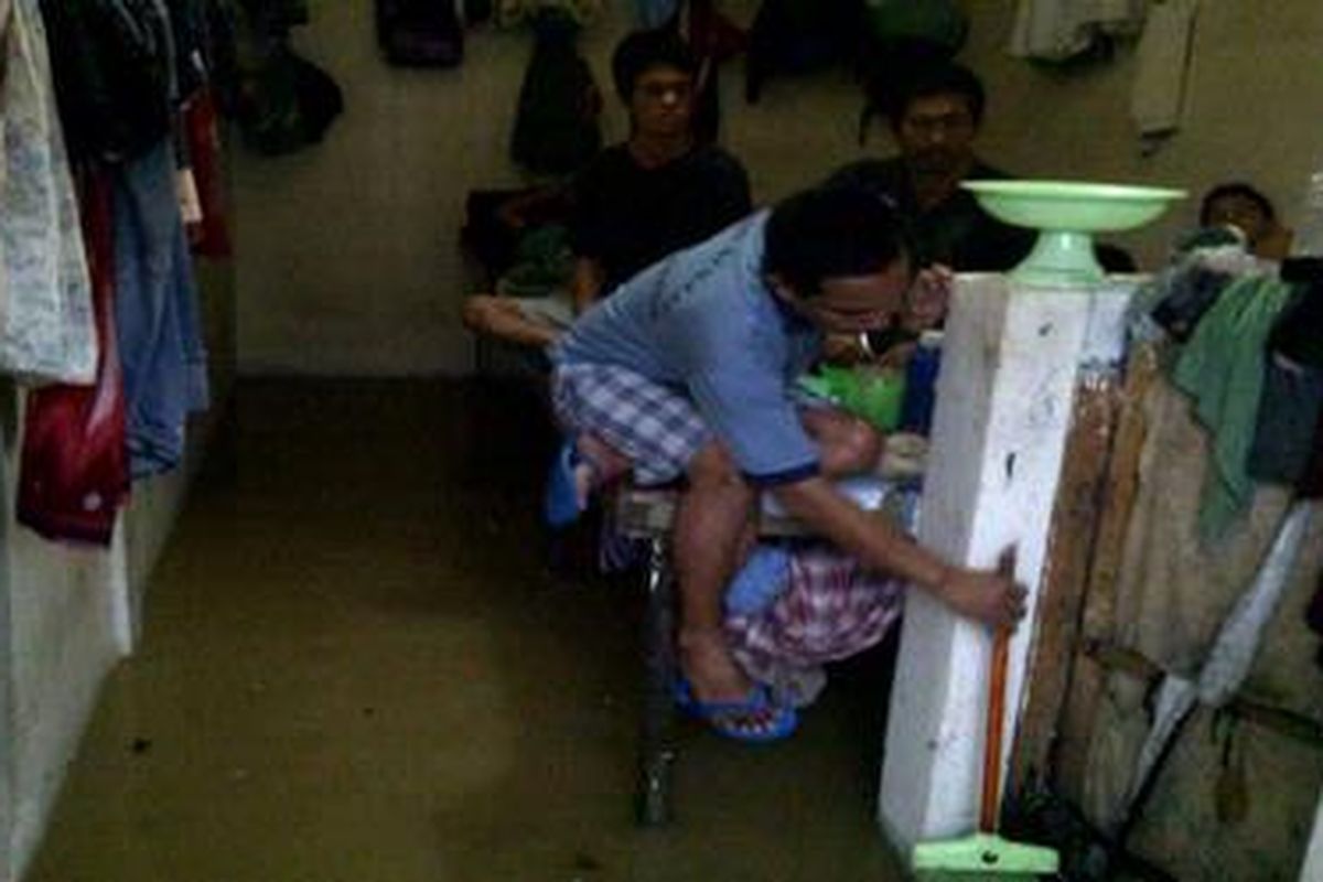 Rutan Batam, Rabu (14/3/2012), kembali kebanjiran. Seorang tahanan sedang berusaha mengeluarkan air yang menggenangi sebuah ruangan.