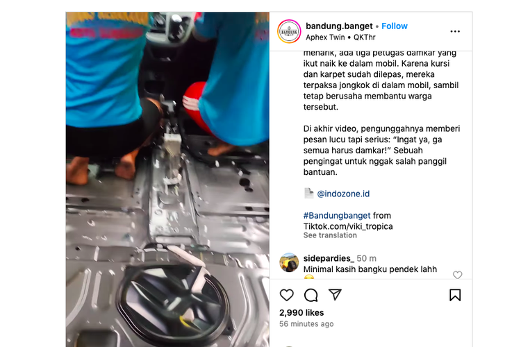 Petugas pemadam kebakaran membantu pemilik mobil yang kebanjiran.