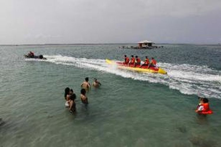Wisatawan berenang dan bermain 'banana boat' di pantai Pulau Tidung, Kepulauan Seribu, Sabtu (14/5/2011). Pulau ini kian dikenal sebagai salah satu destinasi wisata bahari. Pada hari libur, pulau yang memiliki lebar sekitar 200 meter dan panjang hanya 5 kilometer, ini ramai dikunjungi wisatawan.