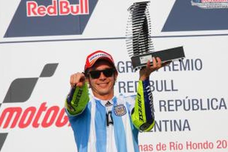 Pebalap Movistar Yamaha asal Italia, Valentino Rossi, merayakan kemenangan GP Argentina di atas podium Sirkuit Termas de Rio Hondo, Minggu (19/4/2015).