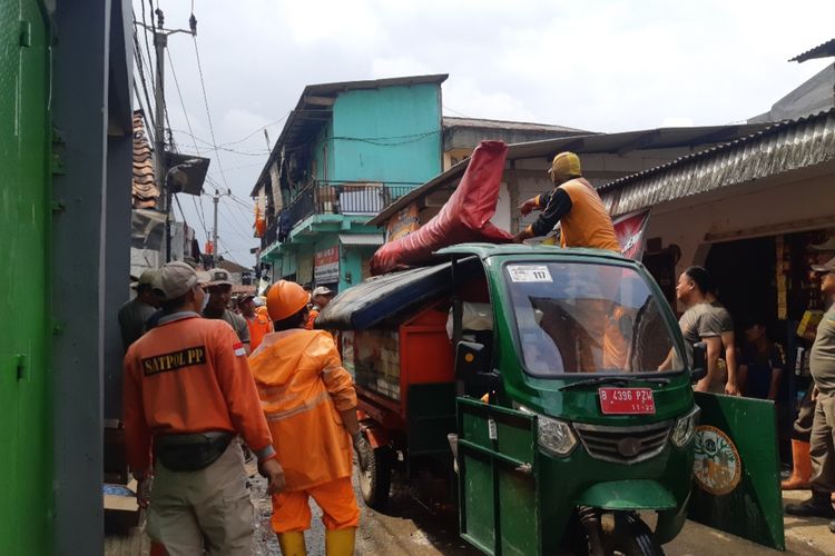 Petugas PPSU mengangkut sampah sisa banjir di Jakarta Barat