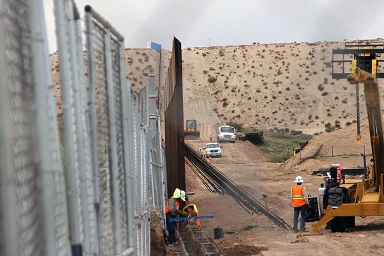 Pekerja AS mengganti pagar dengan dinding baja baru yang lebih tinggi di sepanjang perbatasan antara Ciudad Juarez dan Sunland Park, New Mexico, di wilayah Juarez, negara bagian Chihuahua, Meksiko pada 12 September 2016.
