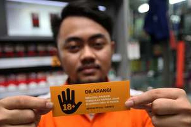 Karyawan Twelve Mart menunjukkan stiker larangan menjual produk tembakau pada anak-anak di Twelve Mart Ampera Raya, Cilandak Timur, Jakarta, Rabu (30/11/2016). Sampoerna memperkuat komitmen untuk mencegah akses penjualan rokok kepada anak-anak di bawah 18 tahun melalui kerja sama dengan para mitra dagangnya untuk menjalankan Program Pencegahan Akses Pembelian Rokok oleh Anak-anak (PAPRA) di 32.300 ritel.